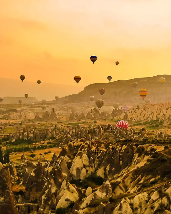 Hot-air balloons over fairy chimneys at sunrise, Cappadocia